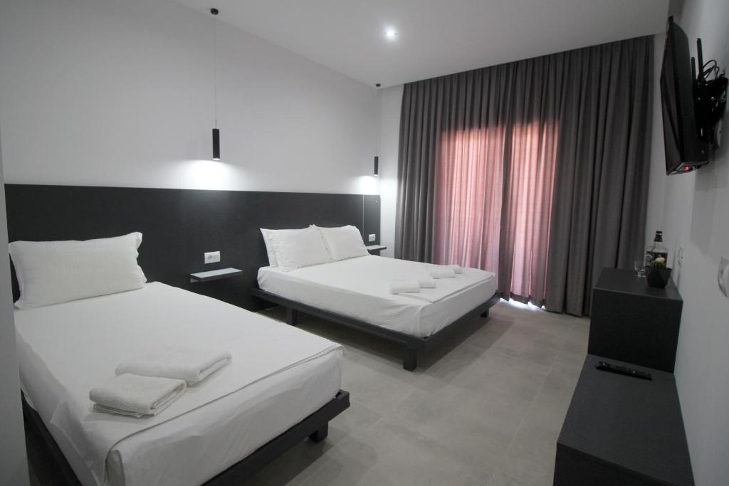 Habitación de hotel con 2 camas y TV en Art De Jon Rooms en Sarandë