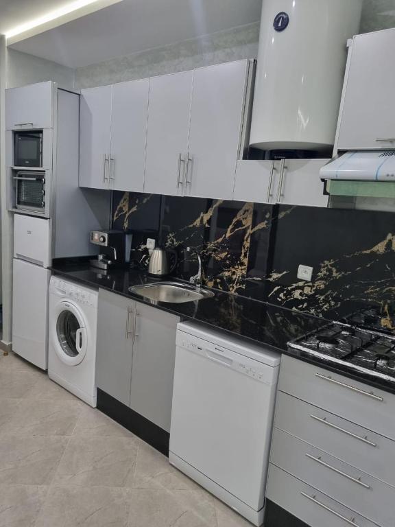 弗尼迪克的住宿－Comfors Appartements 2，厨房配有白色橱柜、洗衣机和烘干机