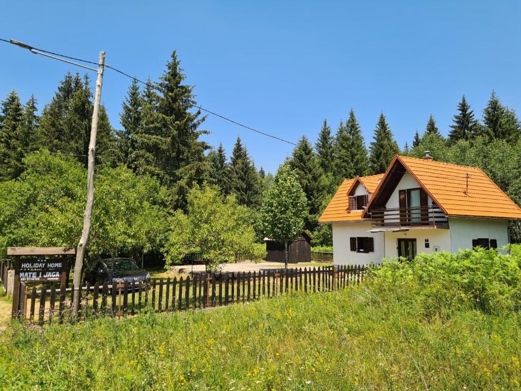 a house with an orange roof and a fence at Mate i Jaga in Saborsko
