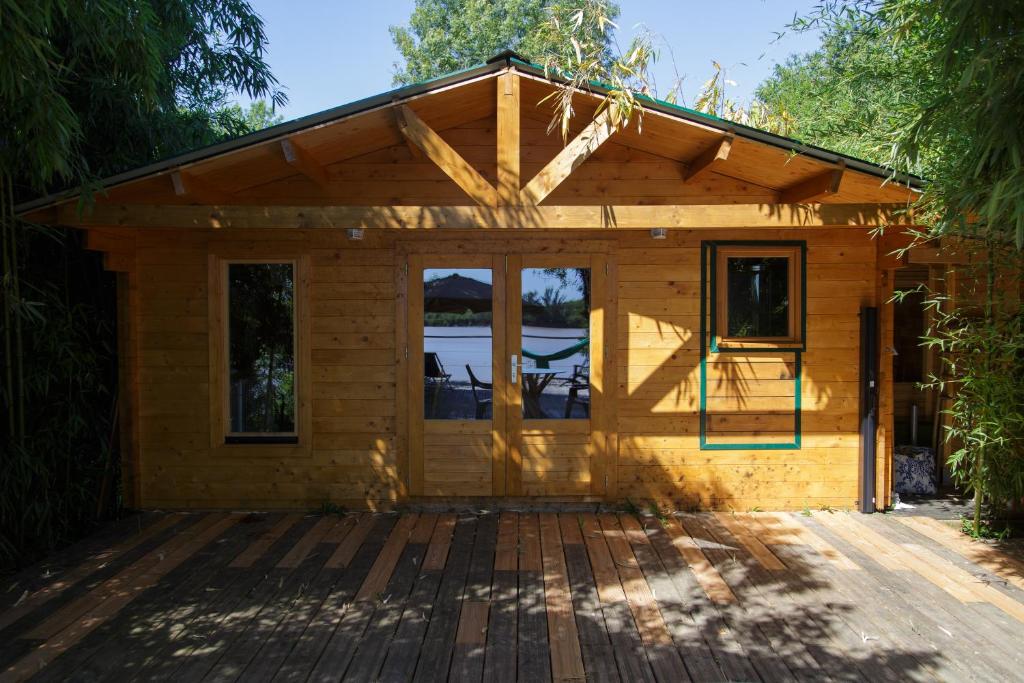 eine kleine Holzhütte mit einer Terrasse in der Unterkunft CABANE BAMBOU in Fronsac