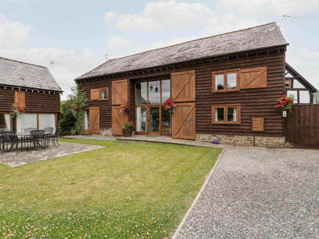ein Holzhaus mit Rasen davor in der Unterkunft Tippets View in Pembridge