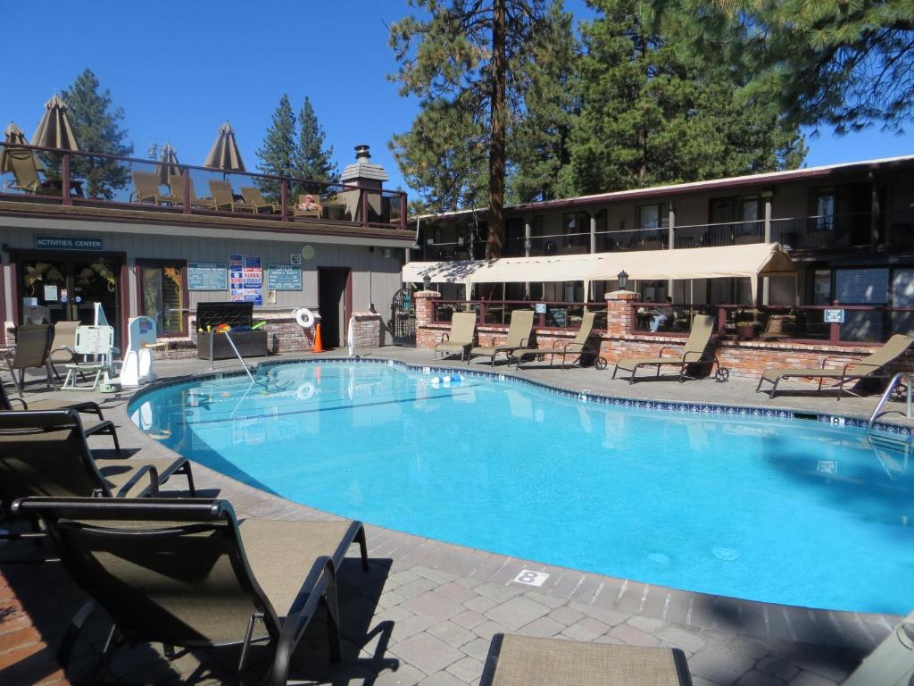 a large swimming pool with chairs and a hotel at Stardust Lodge in South Lake Tahoe
