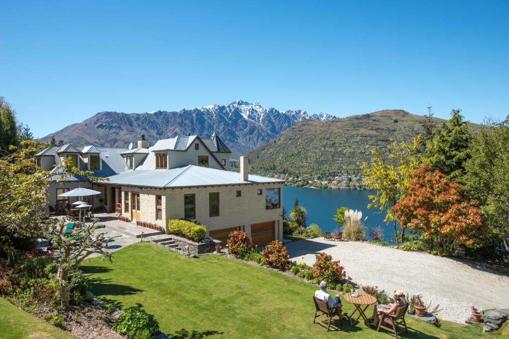 an aerial view of a house with a lake and mountains at Pencarrow Boutique Lodge in Queenstown
