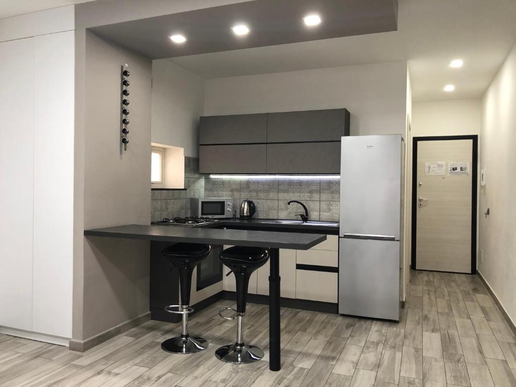 kuchnia z czarnym blatem i lodówką w obiekcie Sunrise Beach Apartment Trapani w Trapani