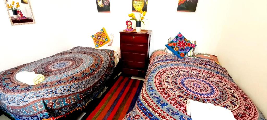 dos camas sentadas una al lado de la otra en un dormitorio en Hostel mágico San Blas, en Cusco