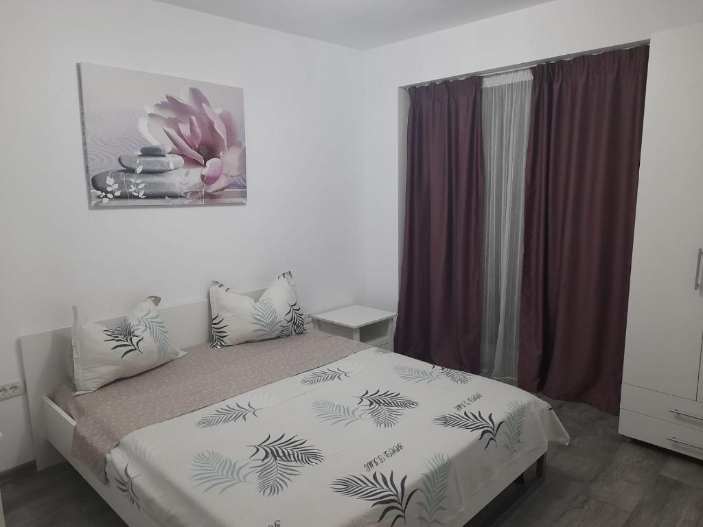 コンスタンツァにあるDarius Apartamentのベッドルーム1室(ヤシの木が敷かれた白いベッドカバー付)