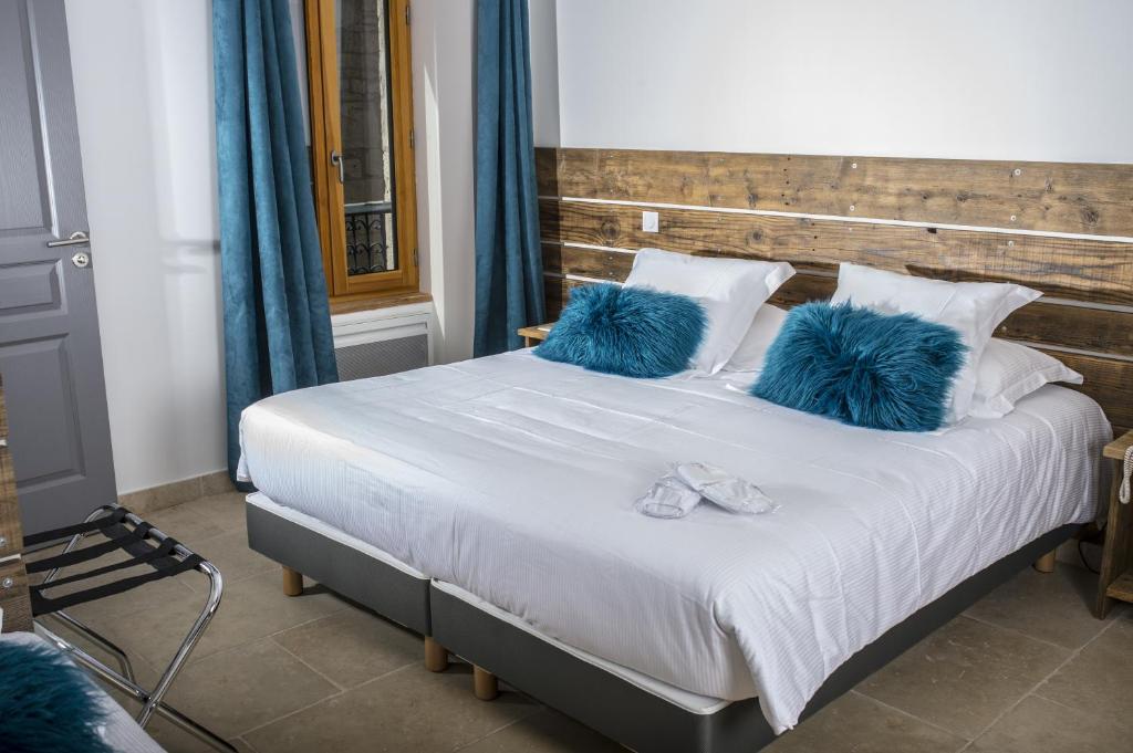 - une chambre avec un grand lit et des oreillers bleus dans l'établissement La Tissandière, à Lalbenque
