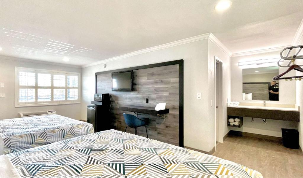 Una habitación de hotel con dos camas y un escritorio. en Motel 6 Pico Rivera - Los Angeles, CA, en Pico Rivera