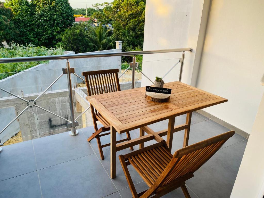 a wooden table and two chairs on a balcony at K'Noly in Baie-Mahault