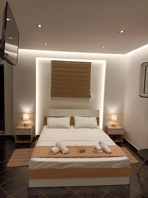 a bedroom with a large bed with two lamps at ALEXANDER APARTMENT'S in Kallithea Halkidikis