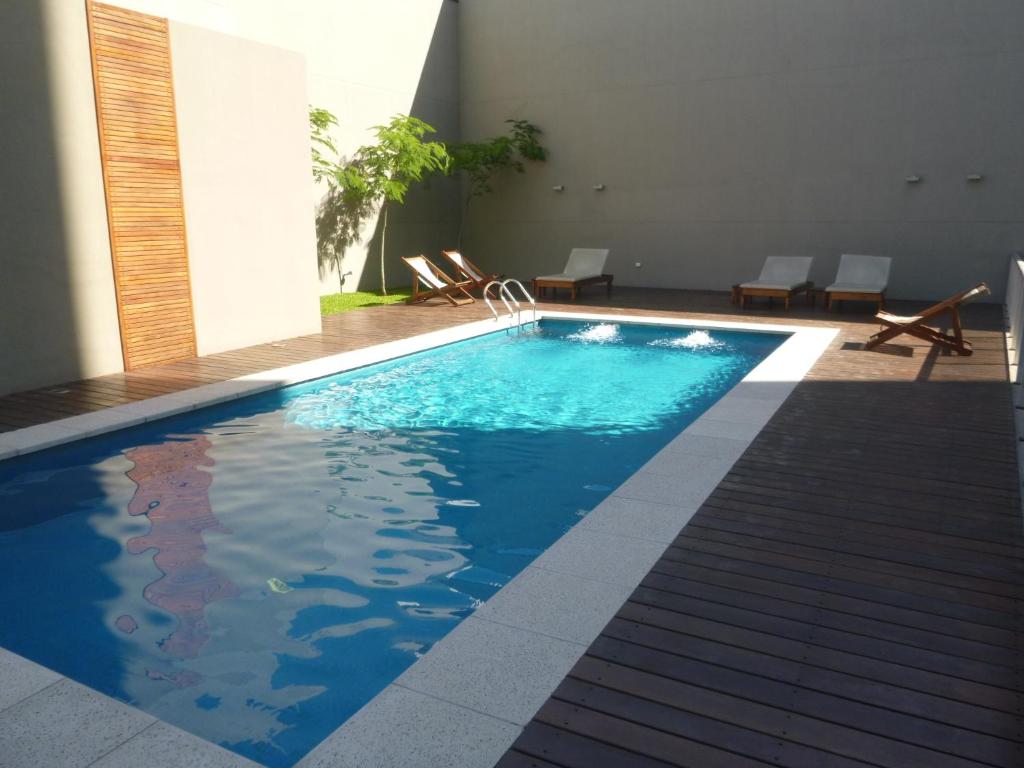 a swimming pool with blue water in a building at Sissi Apart in Buenos Aires