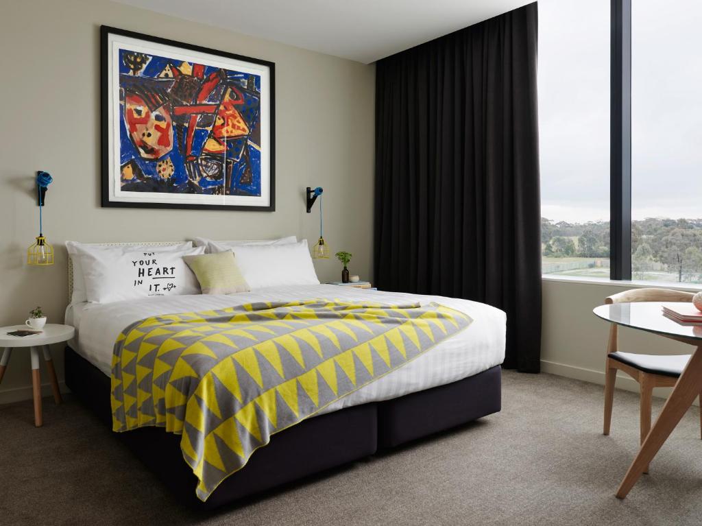 a hotel room with a bed with a yellow and black blanket at Art Series - The Larwill Studio in Melbourne