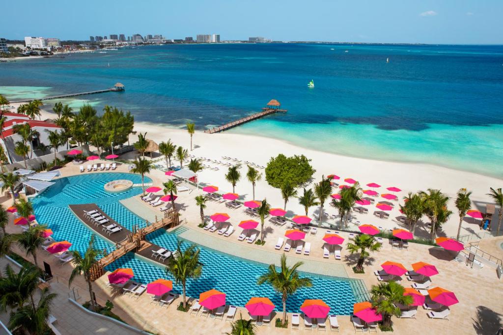 an aerial view of a beach with umbrellas and a pool at Breathless Cancun Soul Resort & Spa - Adults Only - All Inclusive in Cancún