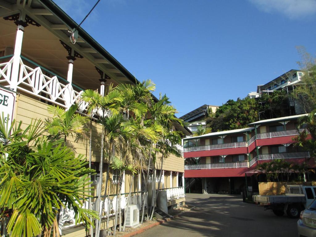a building with palm trees next to a street at Yongala Lodge by The Strand in Townsville