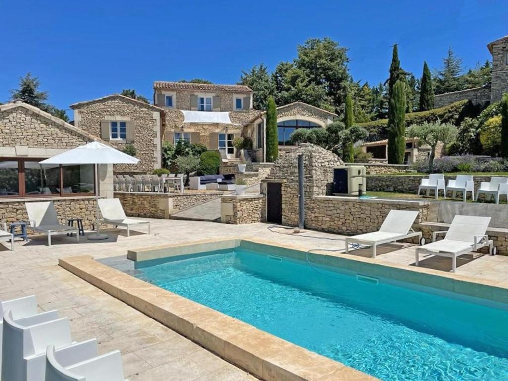 een villa met een zwembad en een huis bij Grands Abayers in Apt