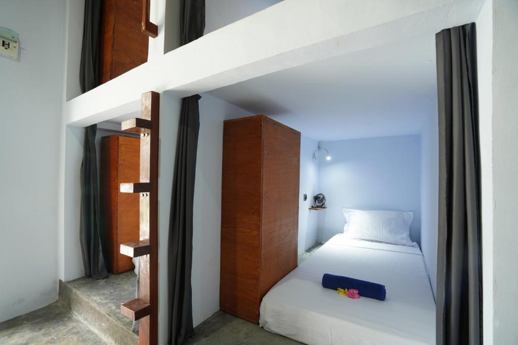 a small bedroom with a bed and a staircase at Waiwas Hostel in Kuta Lombok