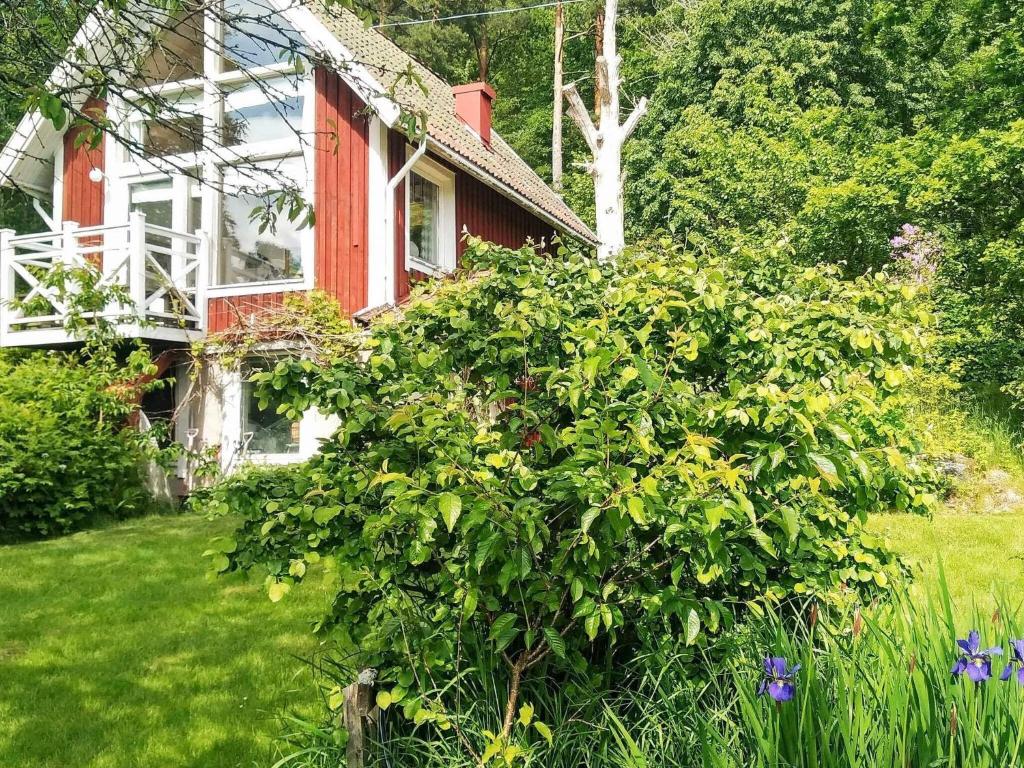 uma casa com um grande arbusto no quintal em 5 person holiday home in FLODA em Floda
