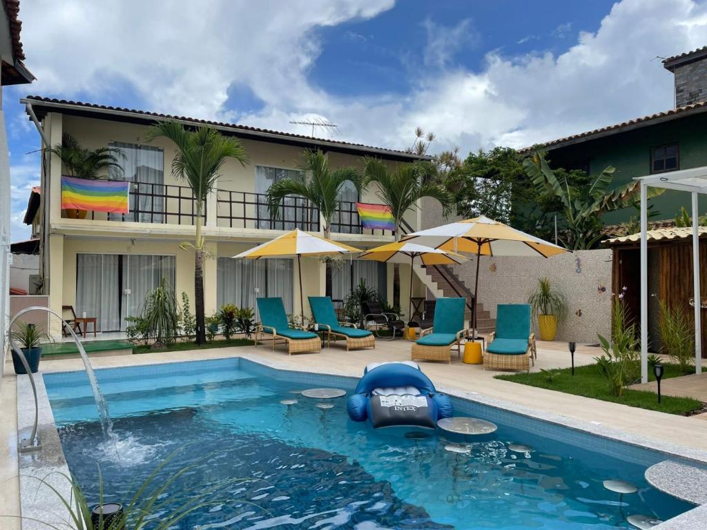 una piscina in un hotel con sedie e ombrelloni di Pousada Villa Encantada LGBTQIAPlus a Salvador