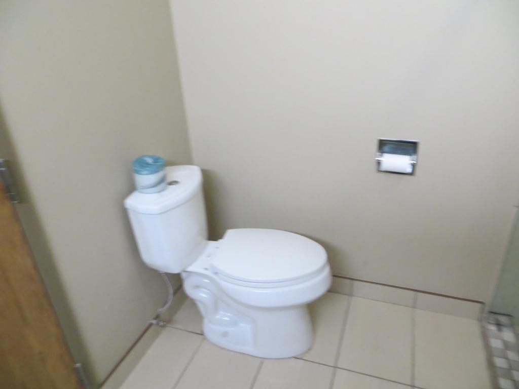 a bathroom with a white toilet in a stall at Super 8 by Wyndham Edmonton/West in Edmonton