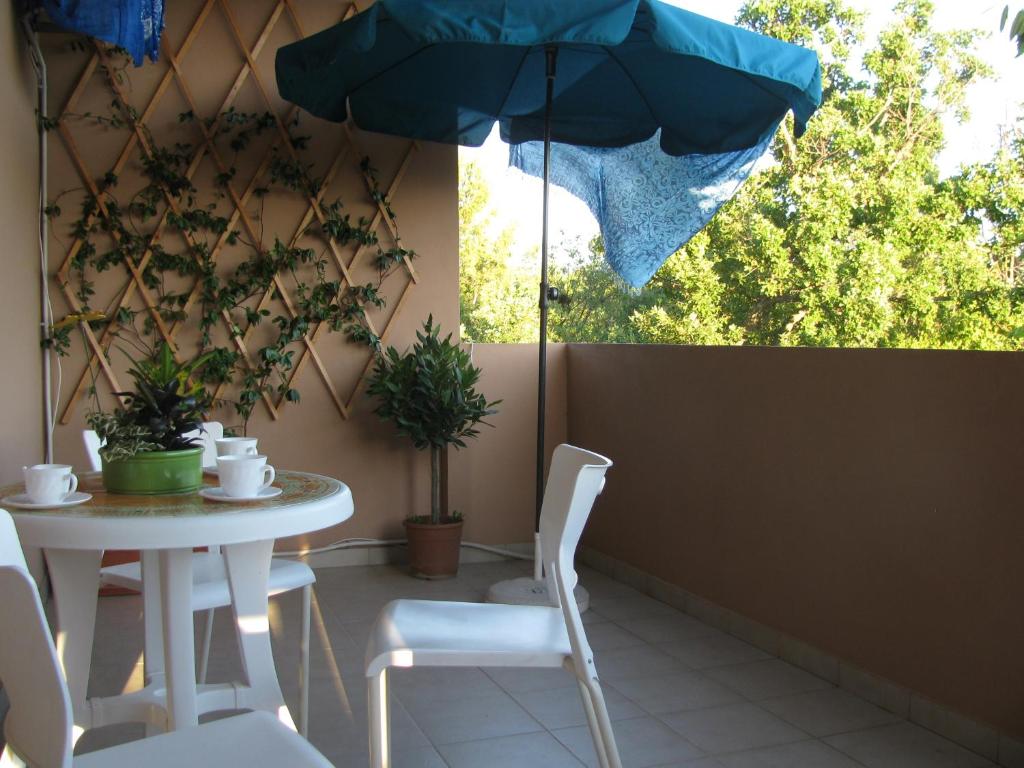 a table and chairs with an umbrella on a patio at Paklina apartments in Starigrad-Paklenica
