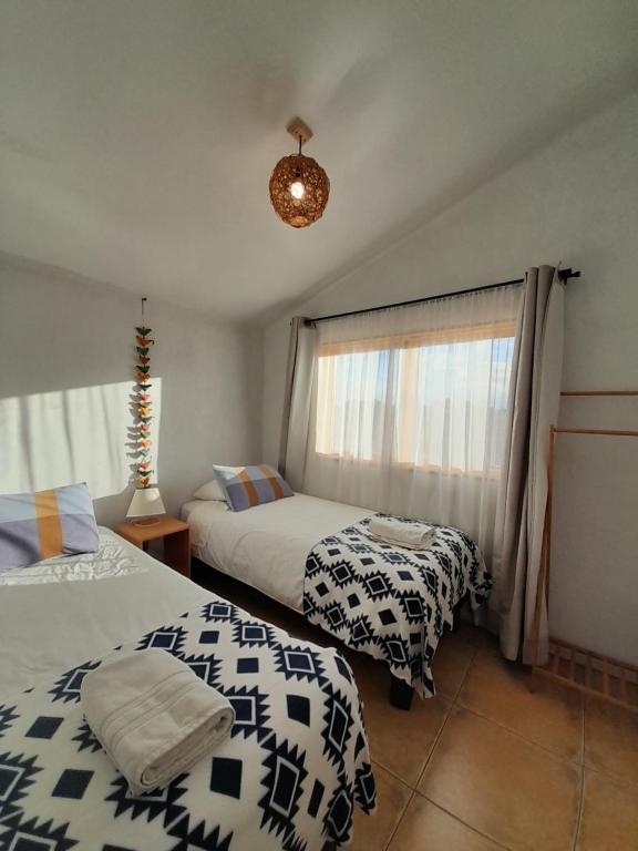 um quarto com 2 camas e uma janela em Eco Parcela La Chacra em Catapilco