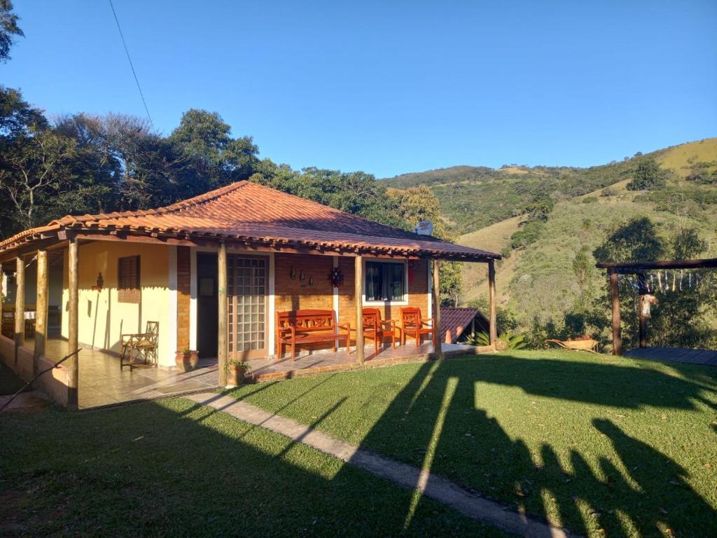 a small house with a porch and a lawn at Cantinho da Roça in Cunha