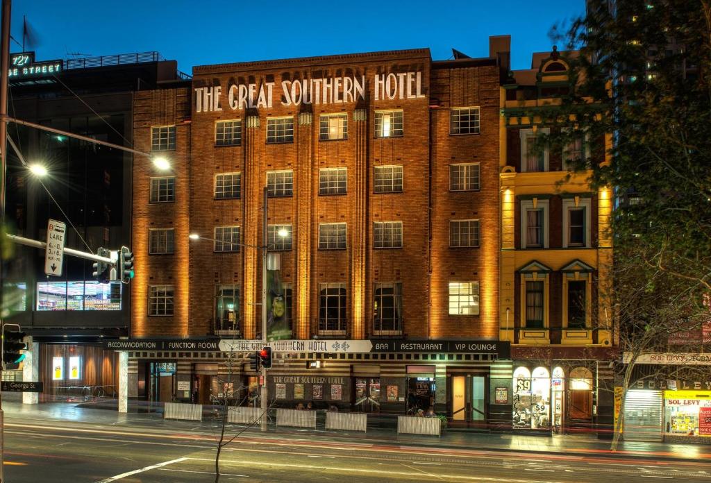 a building on the corner of a street at night at Great Southern Hotel Sydney in Sydney