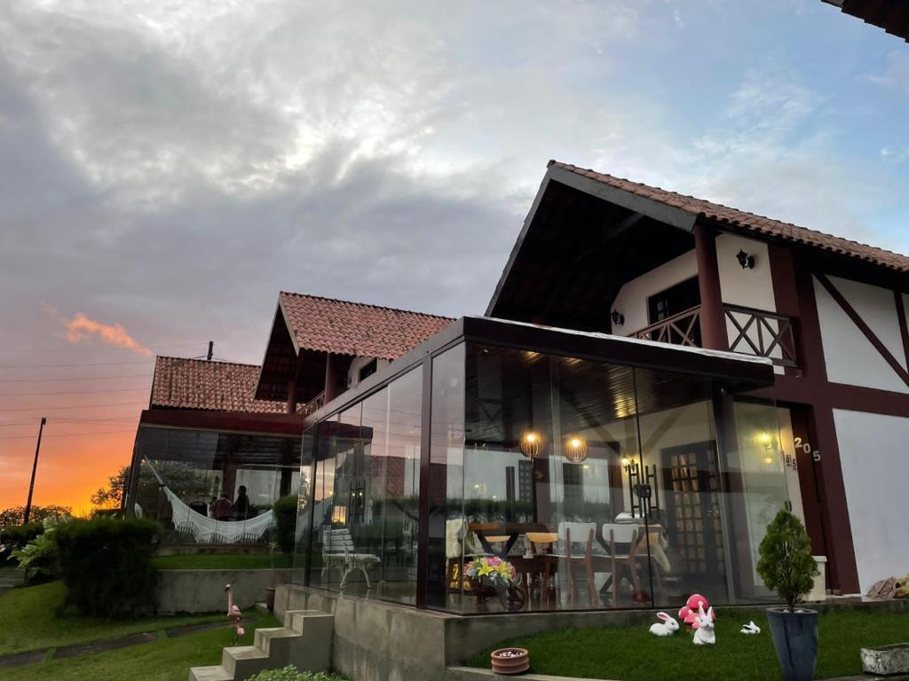 ein Haus mit großen Glasfenstern in der Unterkunft Chalé Serra Nevada - Bananeiras in Bananeiras