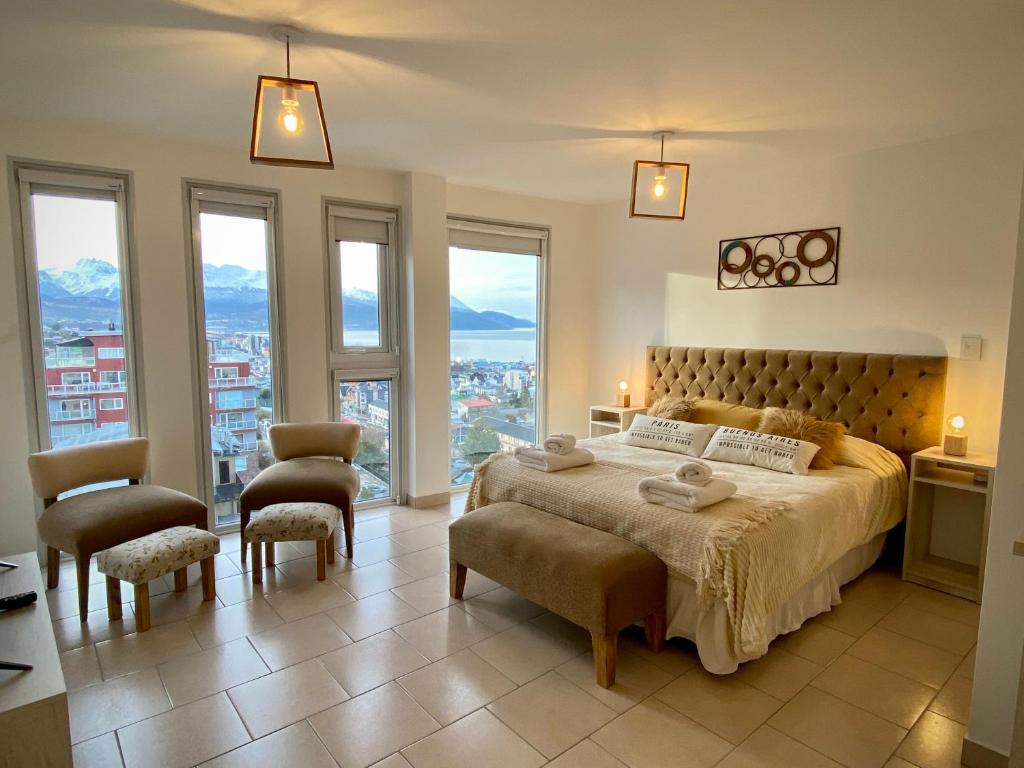 a bedroom with a large bed and some windows at Infinity View Pent House I in Ushuaia