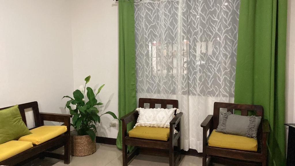 um quarto com duas cadeiras e uma cortina verde em Casa Binisa Fresca y agradable em Libéria