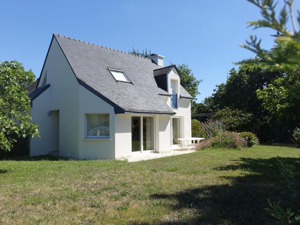una casa blanca con un patio de césped en Maison Saint-Gildas-de-Rhuys, 5 pièces, 10 personnes - FR-1-639-73, en Saint-Gildas-de-Rhuys