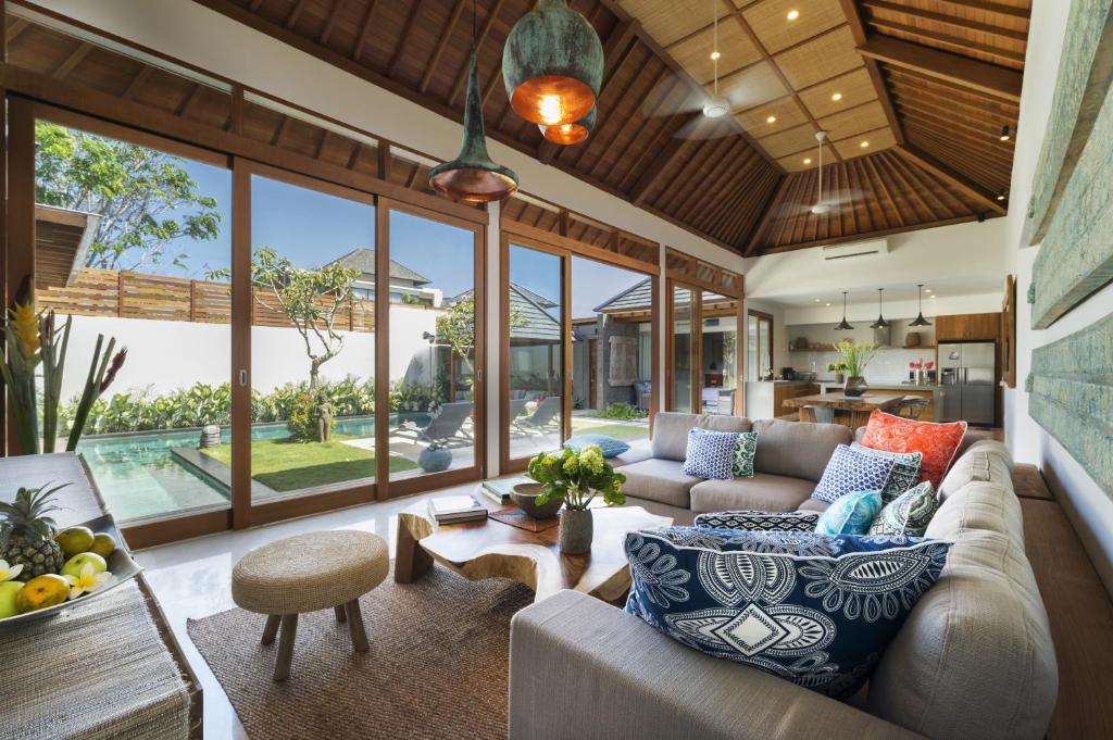 an open living room with a couch and a table at Villa Sanook in Seminyak