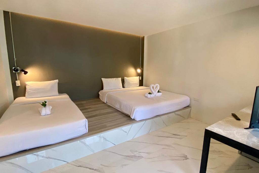 2 Betten in einem Hotelzimmer mit Blumen darauf in der Unterkunft The dream garden in Ao Nang Beach