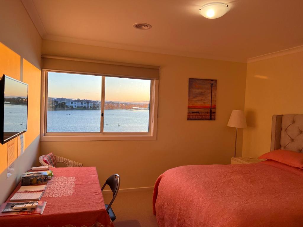 a bedroom with a bed and a large window at King House in Point Cook