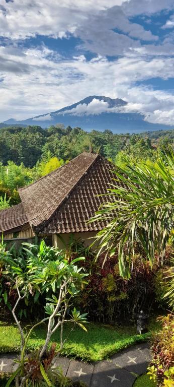 un toit d'une maison avec une montagne en arrière-plan dans l'établissement Giri Carik, à Sidemen