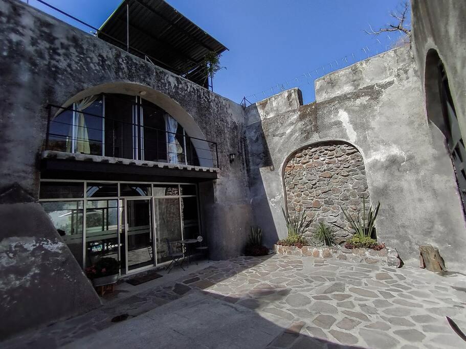 een oud gebouw met een raam en een stenen muur bij Casa con alberca dentro de ex-hacienda en Atlixco in Atlixco