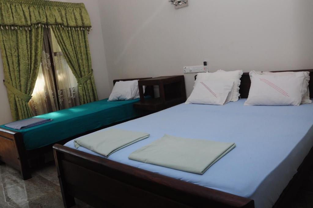 Postel nebo postele na pokoji v ubytování Traveller's Home Hotel