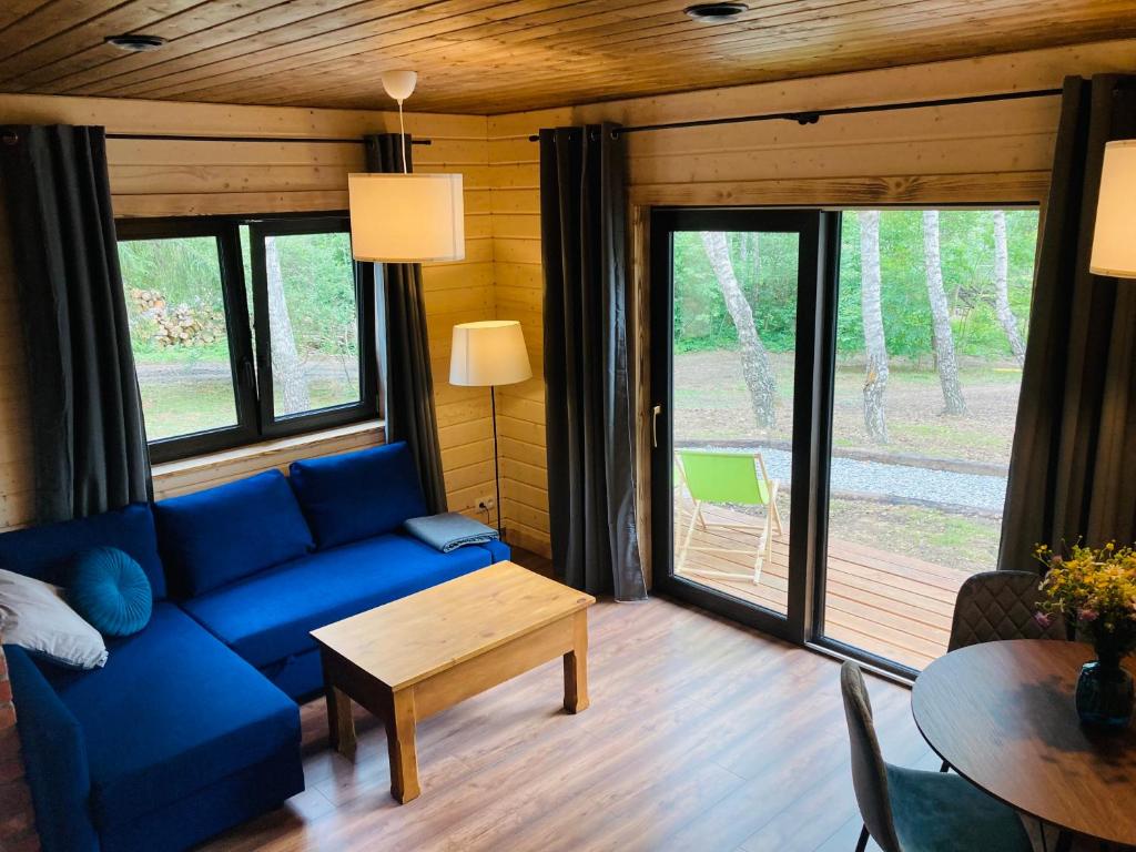 sala de estar con sofá azul y mesa en Modrynowe Domki en Wetlina