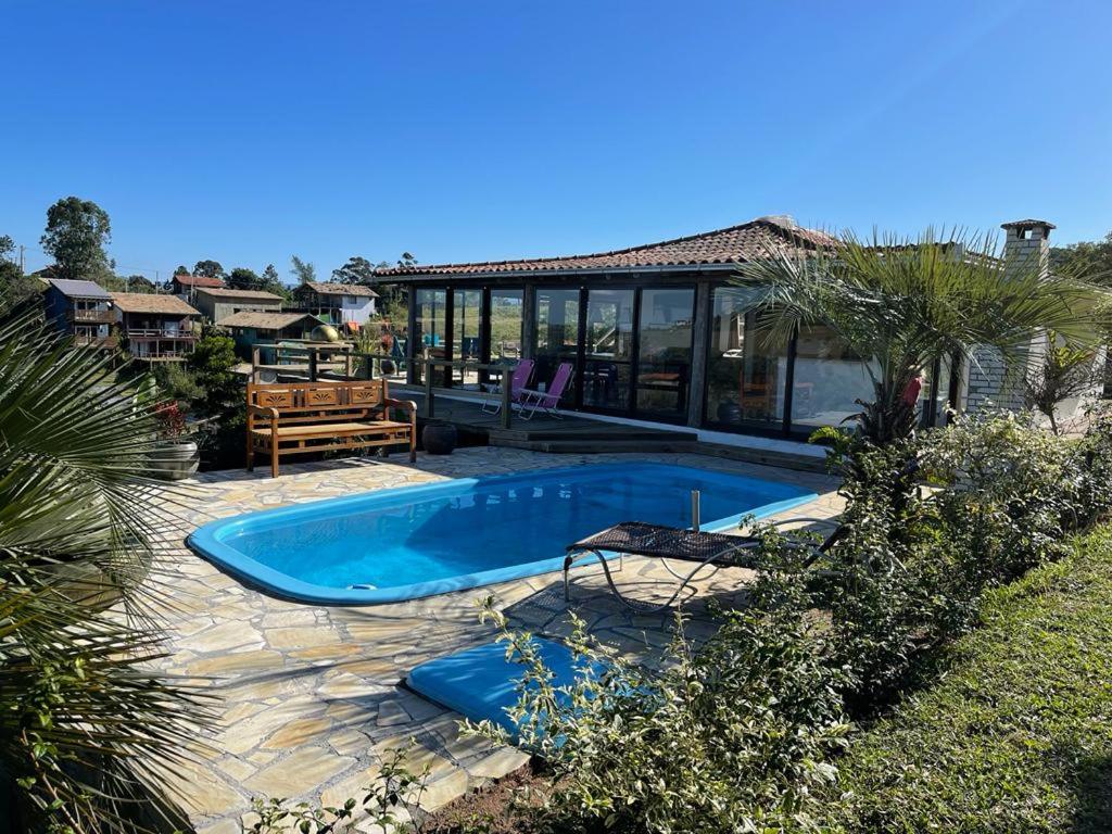 una piscina en el patio trasero de una casa en Villa Santorini Praia do Rosa com piscina e jacuzzi en Praia do Rosa