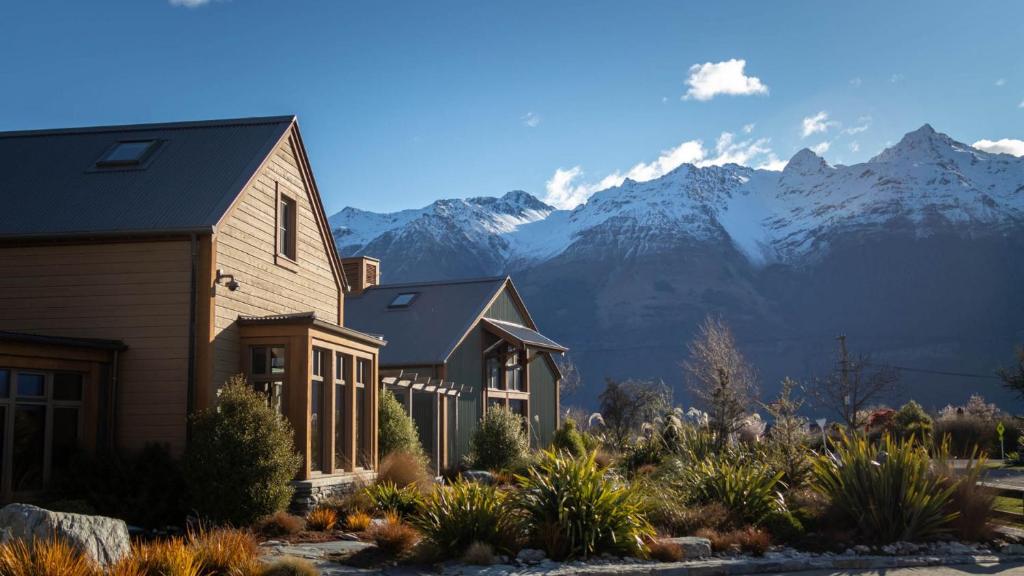 una casa con montañas en el fondo en The Headwaters Eco Lodge, en Glenorchy