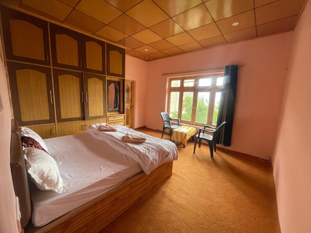 a bedroom with a large bed and a window at Gaywoo Guest House in Leh