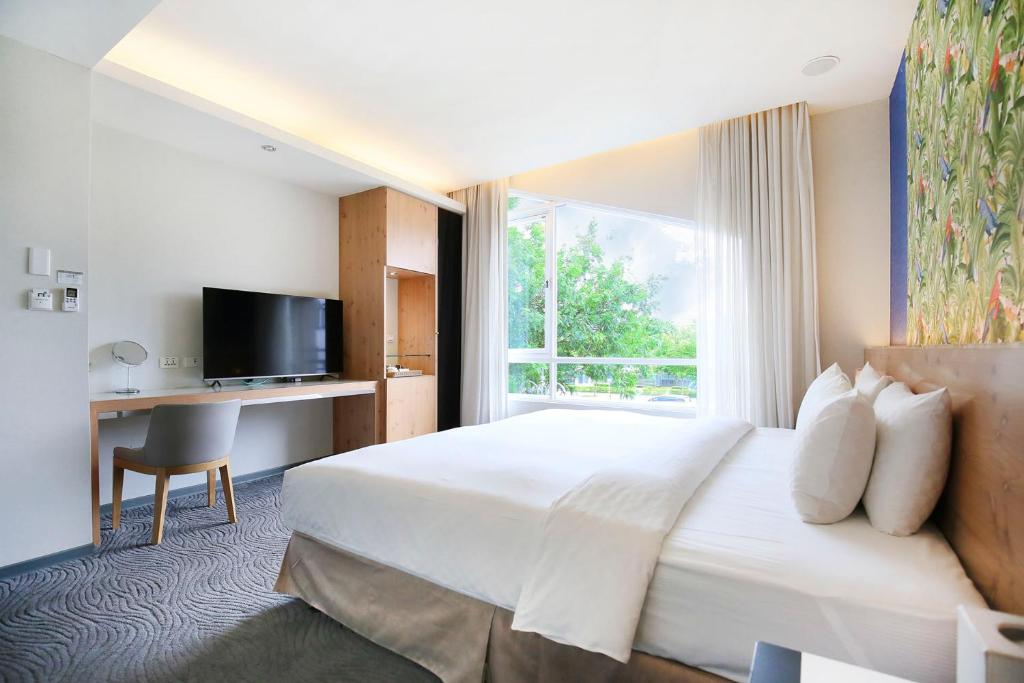 a hotel room with a large bed and a window at Dandy Hotel-Daan Park Branch in Taipei