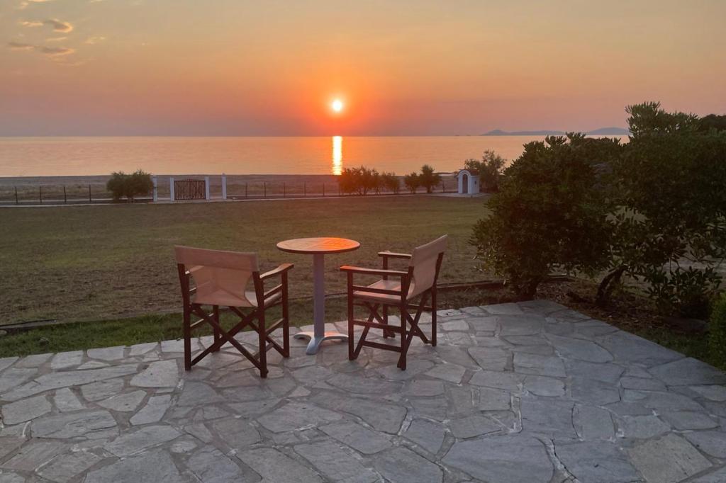 un tavolo e sedie con il tramonto sullo sfondo di Villa Totti a Ierissós