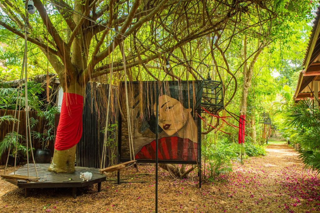 una pintura de un árbol en una jaula junto a un árbol en Alcove Bungalow, en Hinkong