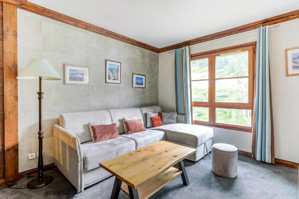 un salon avec un canapé et une table dans l'établissement Résidence Les Arcs 1950 Le Village - maeva Home - Appartement 2 pièces 4 personnes - Prestige MAE-1194, à Bourg-Saint-Maurice