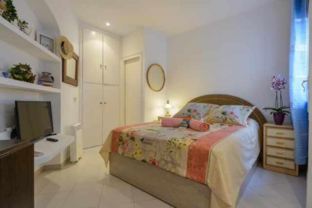 巴古爾的住宿－CapSaSalBegur137 en Playa Privada Piscina del Mar，一间卧室配有一张床和一台平面电视