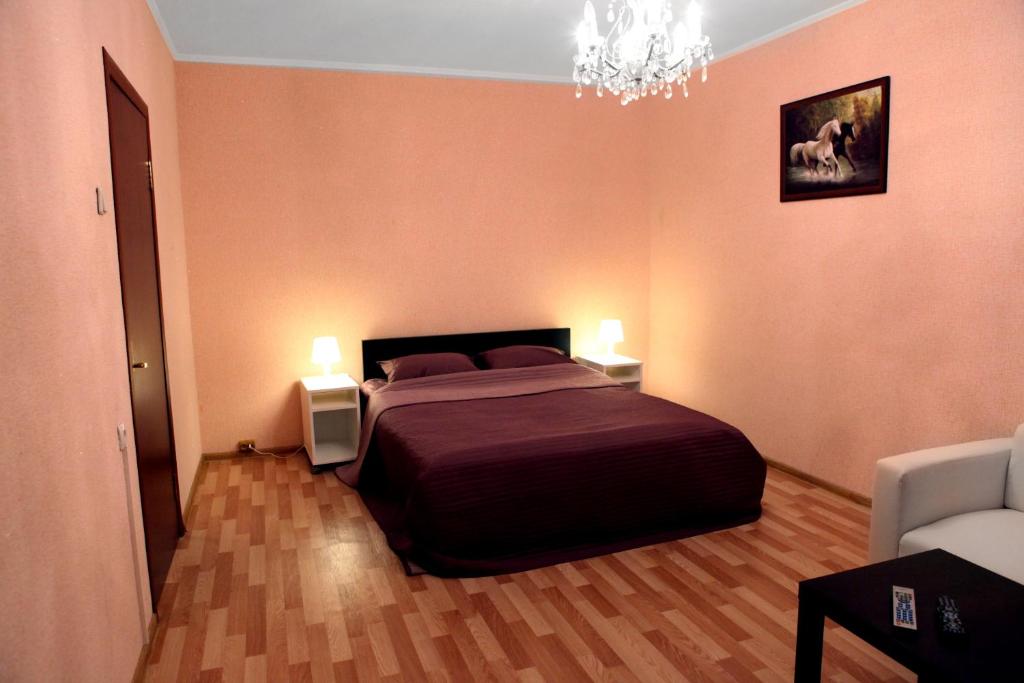 モスクワにあるApartment on Molodyozhnayaのベッドルーム1室(ベッド1台、ランプ2つ、シャンデリア付)
