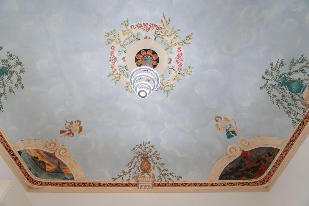 a room with a ceiling with paintings on it at Zagara e Lumia in Catania