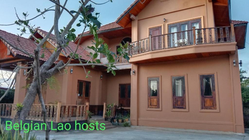 una casa con un balcón en el lateral. en Pukyo Bed and breakfast Belgian lao en Ban Nangoy