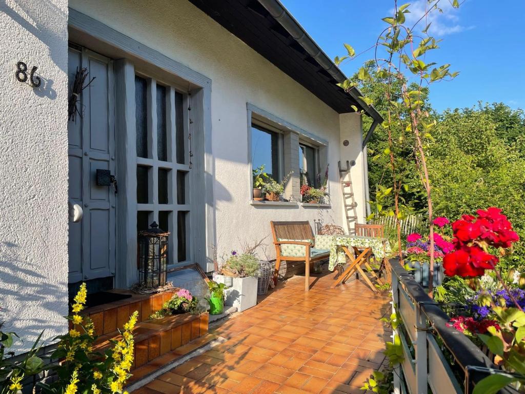 a house with a patio with flowers on it at Ferienwohnung im Daungarten in Oberfell